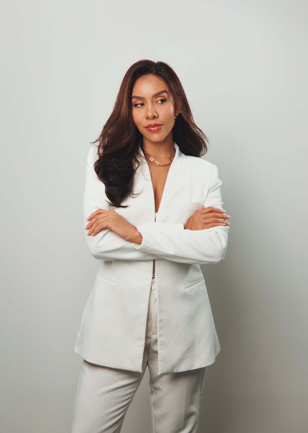 Ana Veiga, de blazer branco e braços cruzados